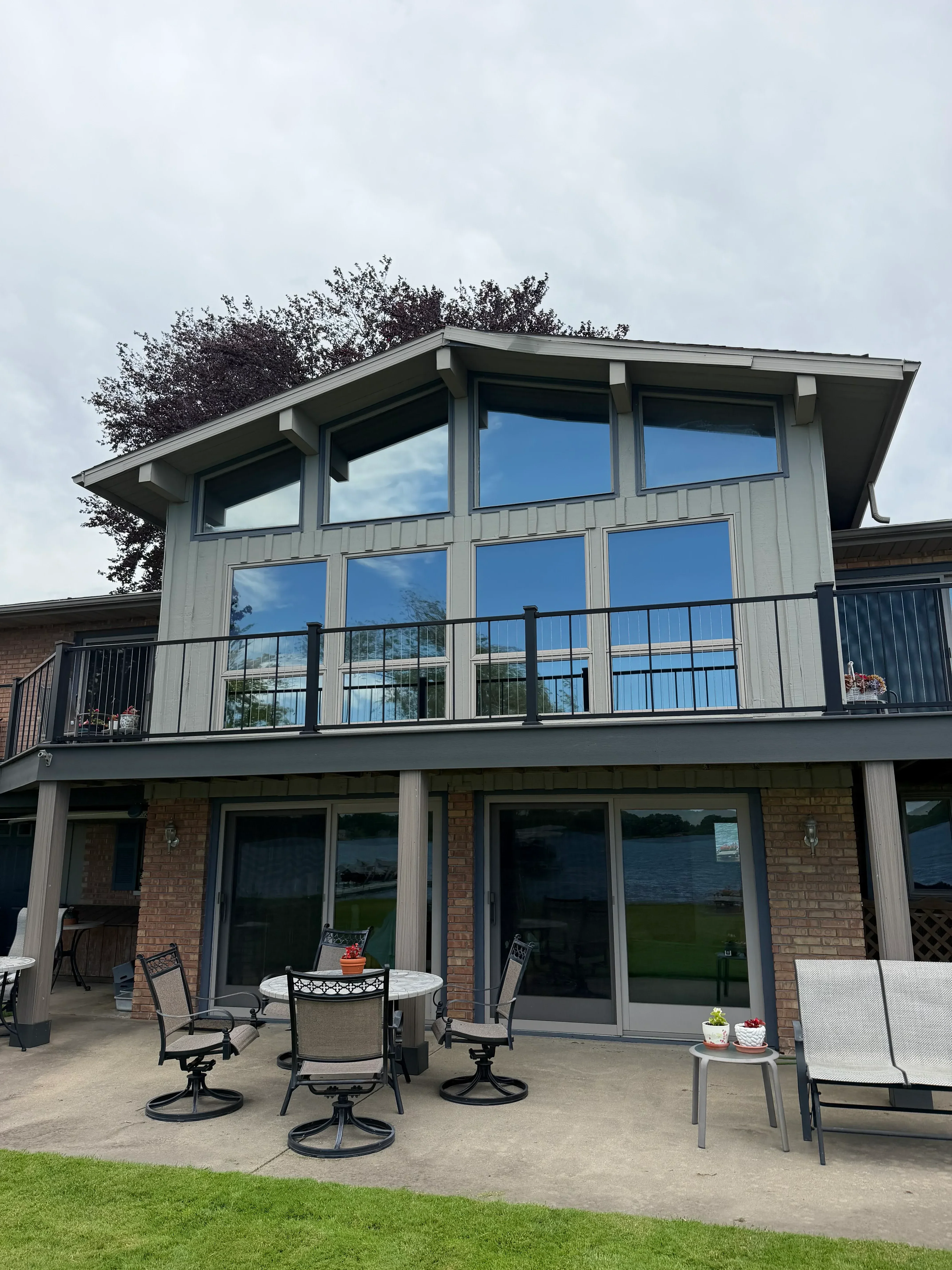 Blue-tinted residential windows with professional film installation on multi-pane home exterior