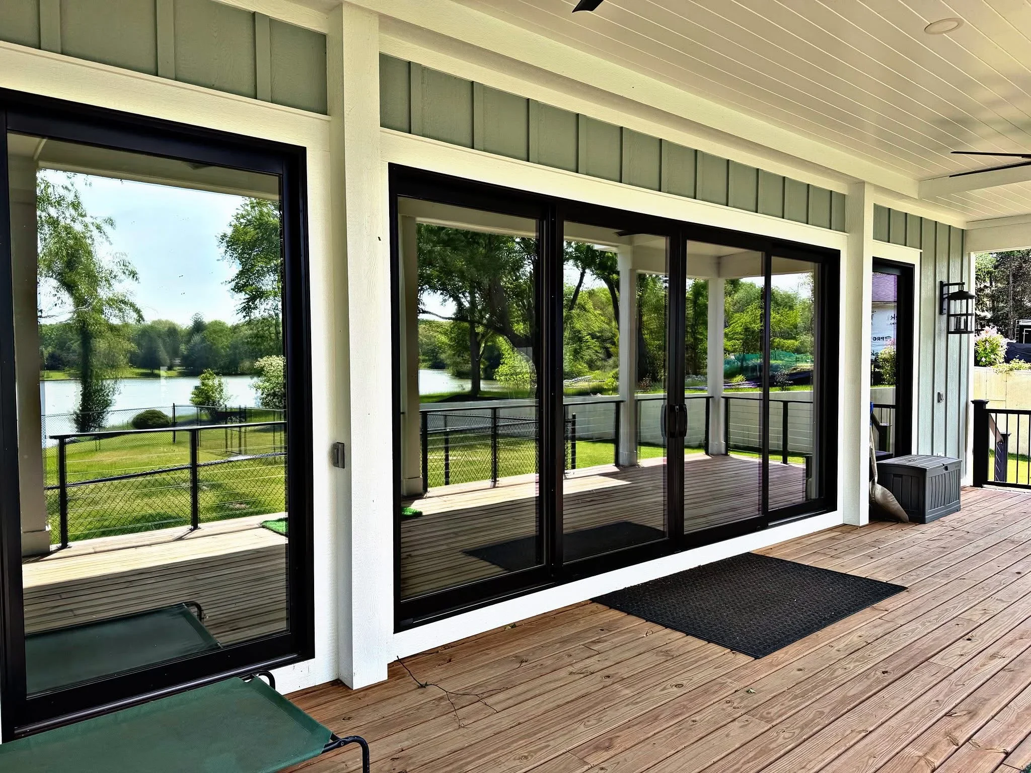 Black-framed sliding glass doors with clear glass panels overlooking waterfront landscape