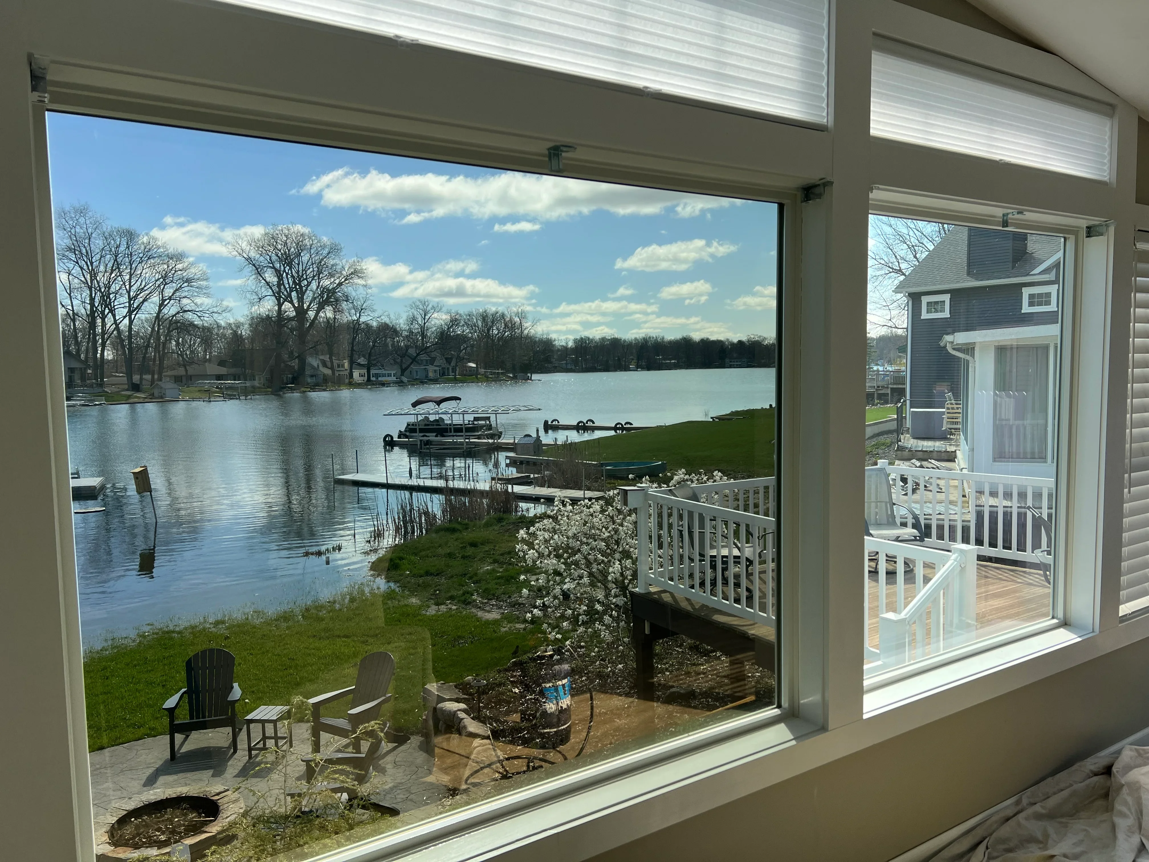 Large sliding glass doors with white frames overlooking lake and waterfront property