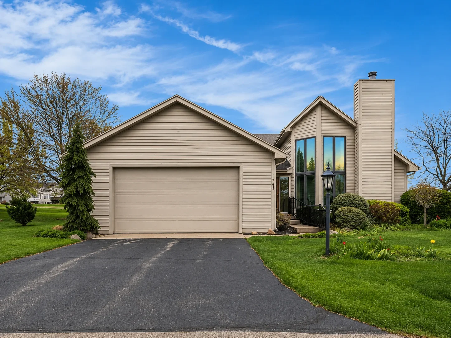 Tinted windows on contemporary home with glass entry doors and tall windows