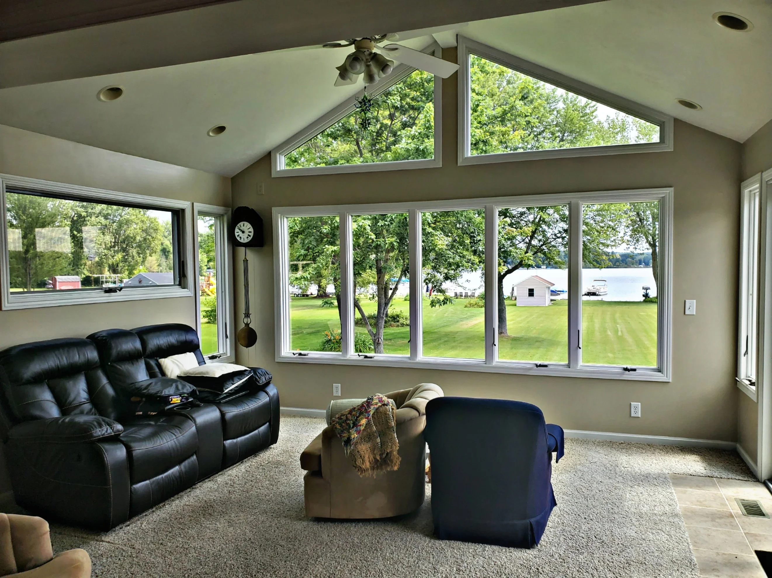 Multi-pane white-framed windows and sliding glass doors in modern living room with lake views