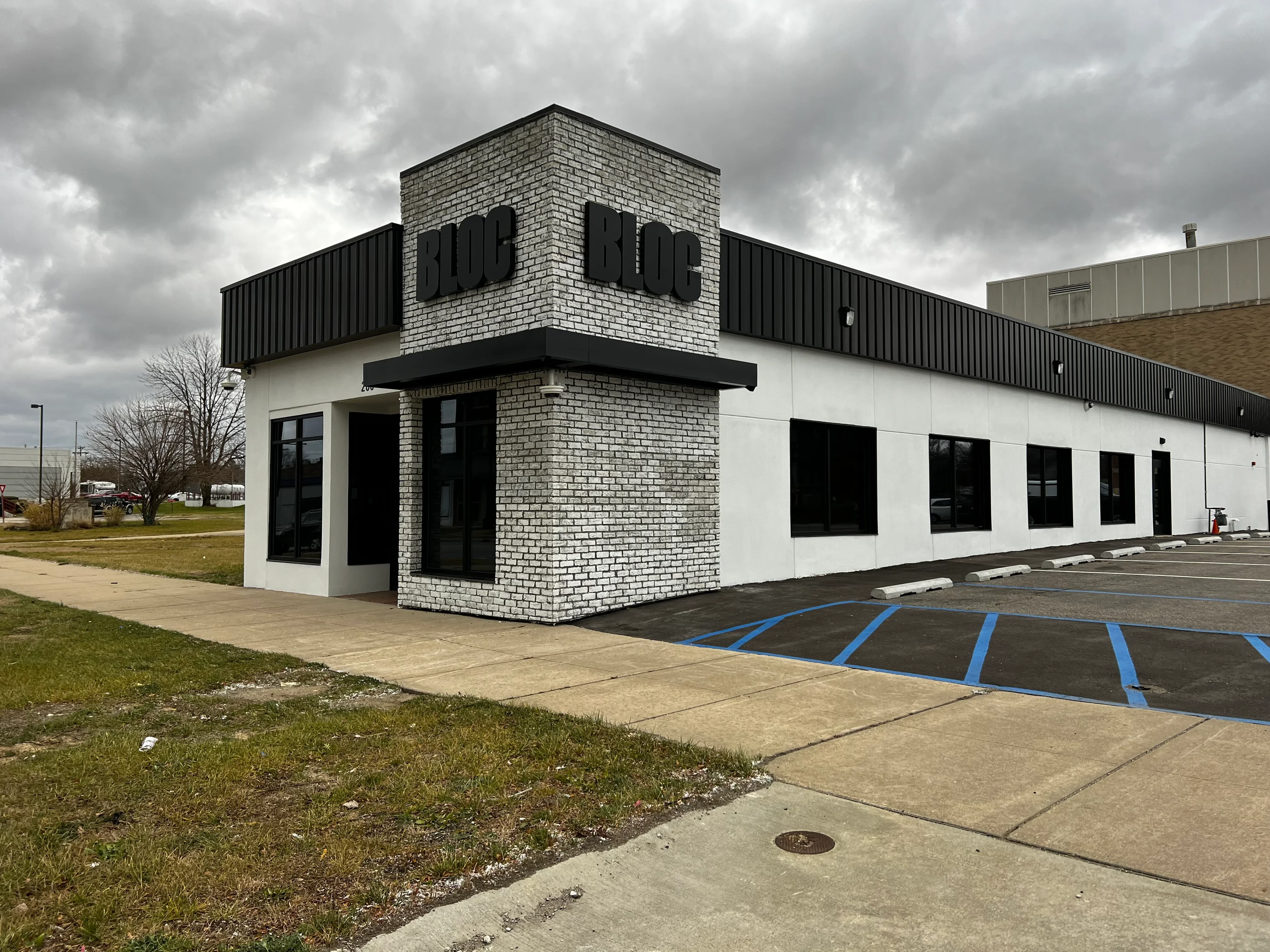 Commercial storefront with tinted windows and glass doors on white and brick facade