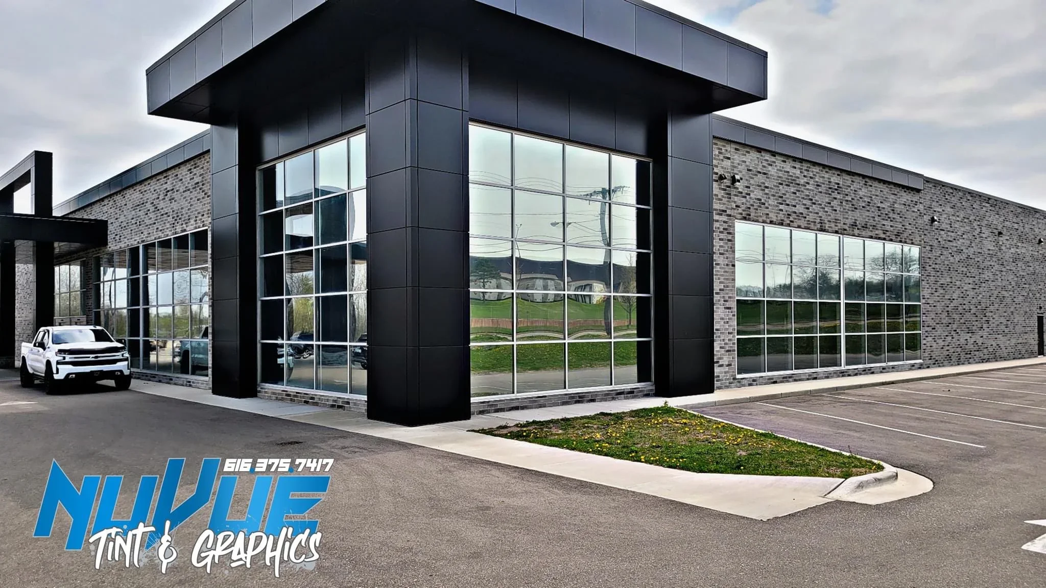 Commercial storefront with tinted floor-to-ceiling windows and gridded glass panels on modern building