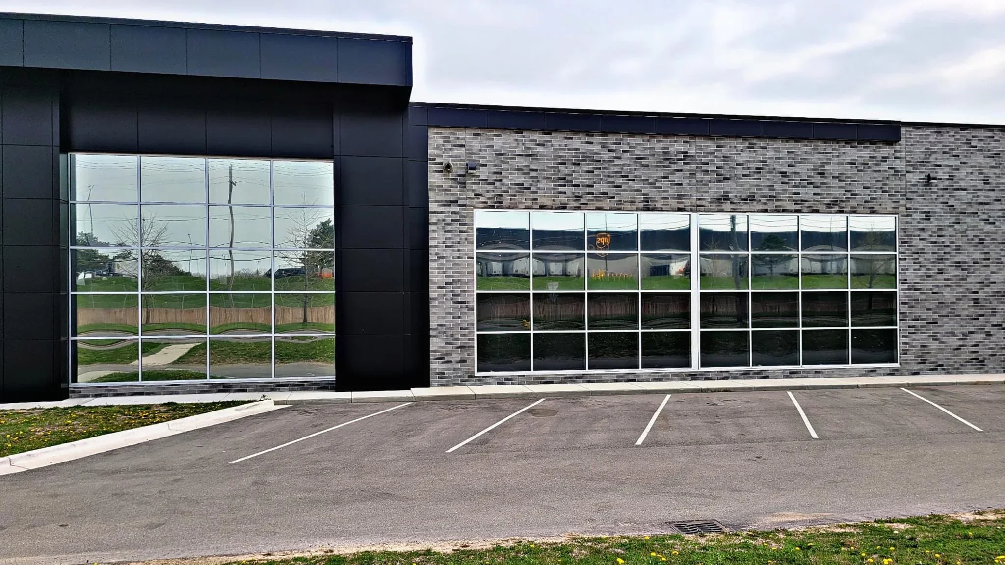 Commercial storefront with tinted windows on brick and metal building facade