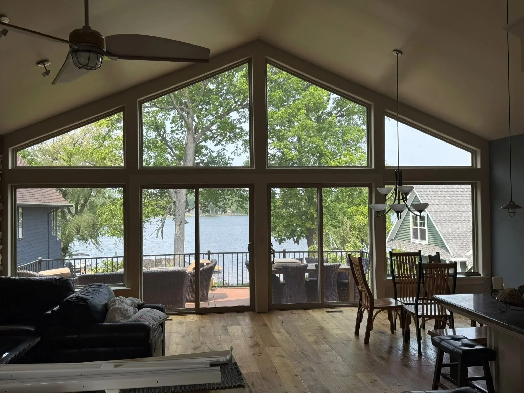 Bronze-framed multi-panel glass doors and transom windows in waterfront great room with water views