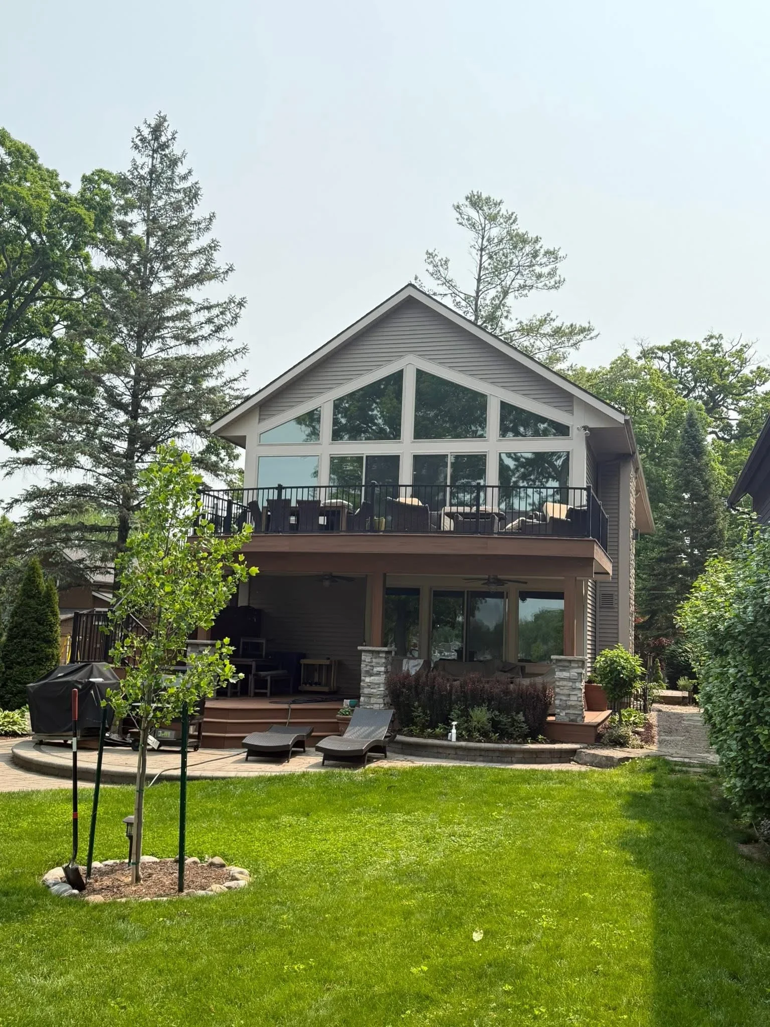 Tinted windows on two-story residential home with large glass panels and deck