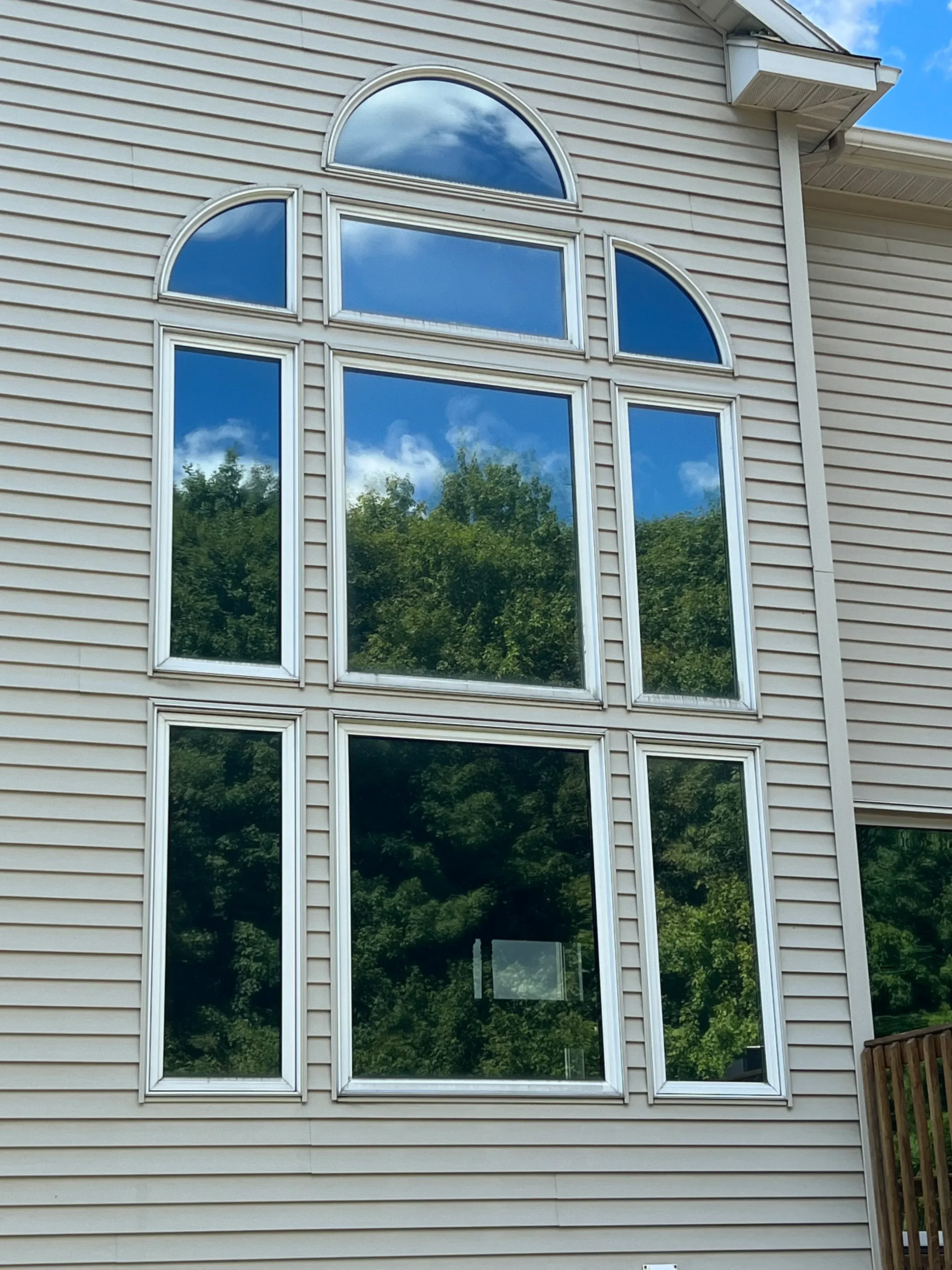 White aluminum-framed windows installed on corrugated metal building facade with curved and rectangular designs