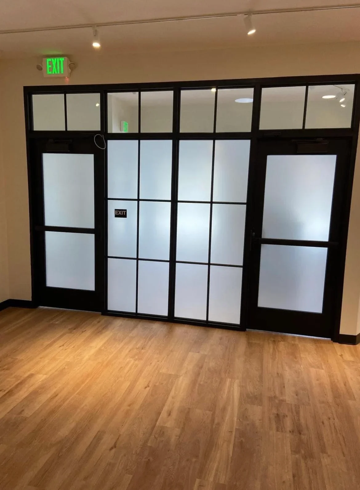 Frosted glass partition with black aluminum frame and multiple panes in commercial space