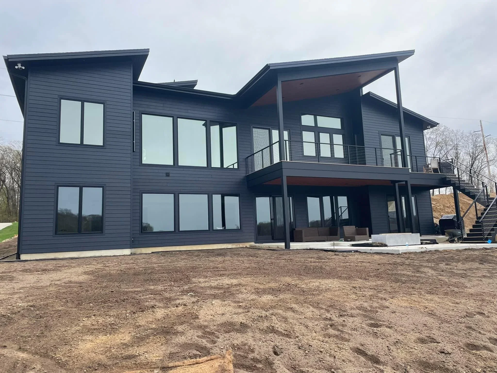 Dark-framed multi-pane windows and glass doors on modern two-story home exterior