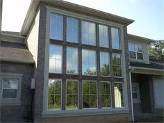 Dark-tinted multi-pane residential windows on home exterior with grid pattern framing