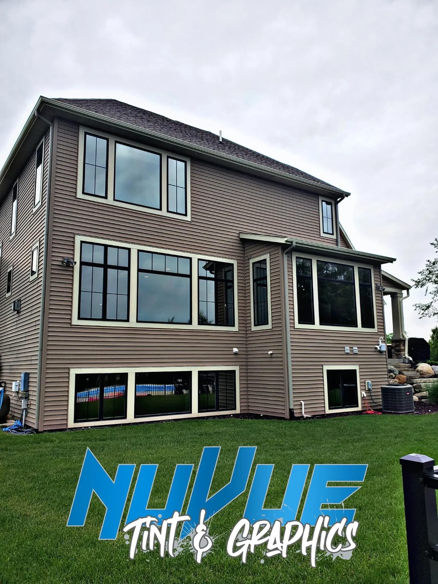 Residential home with professional window tinting on multiple large windows, black frames with white trim