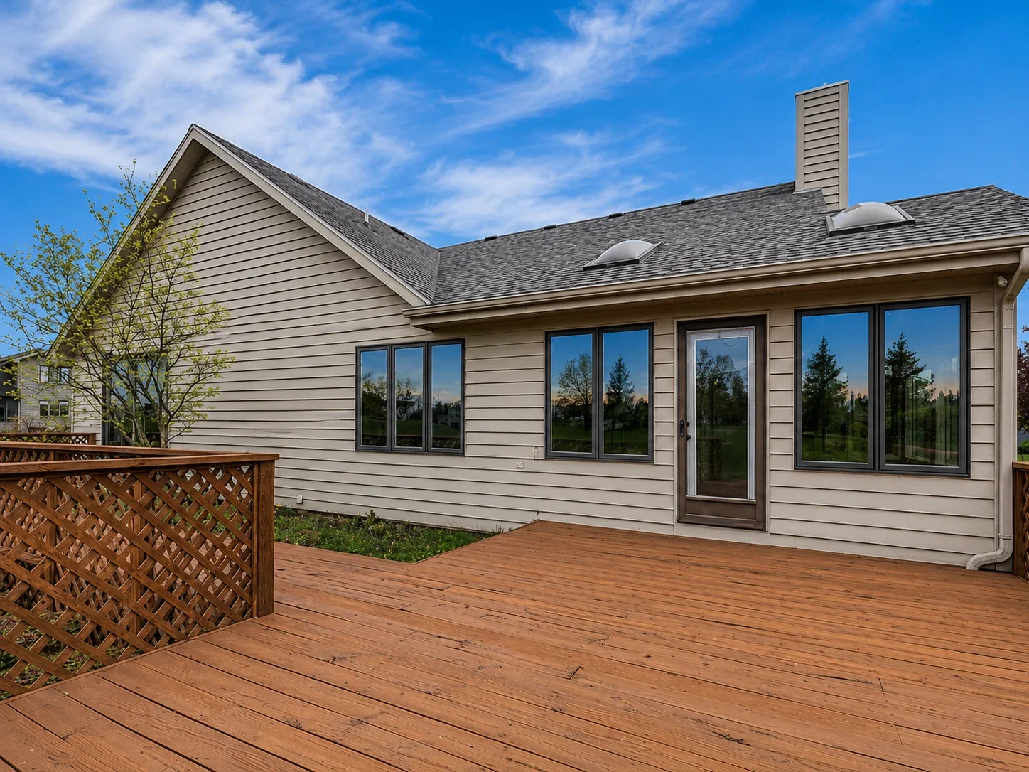Tinted windows on residential home with wood deck and lattice railing