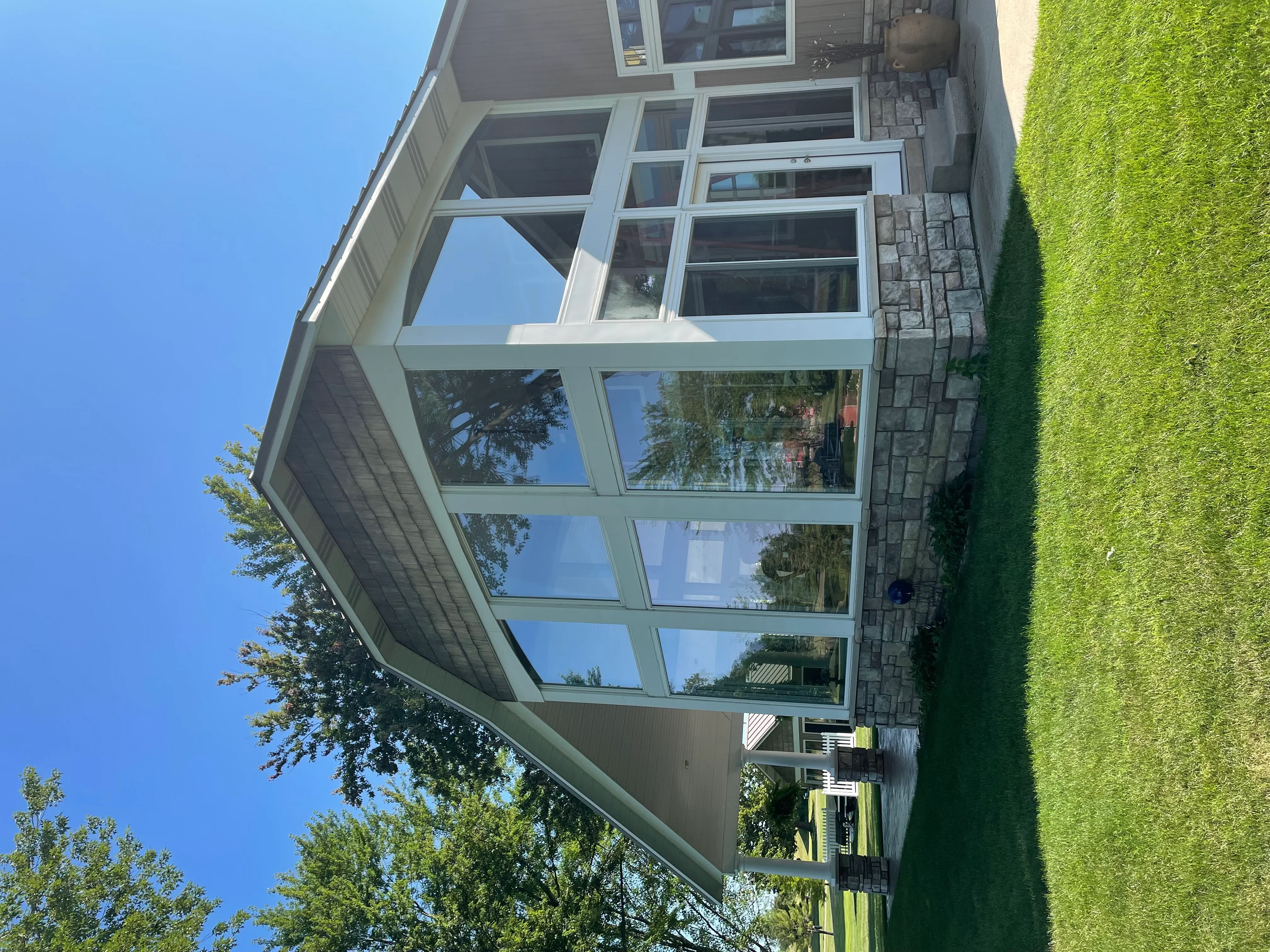 White-framed multi-pane residential windows with professional tinting on home exterior